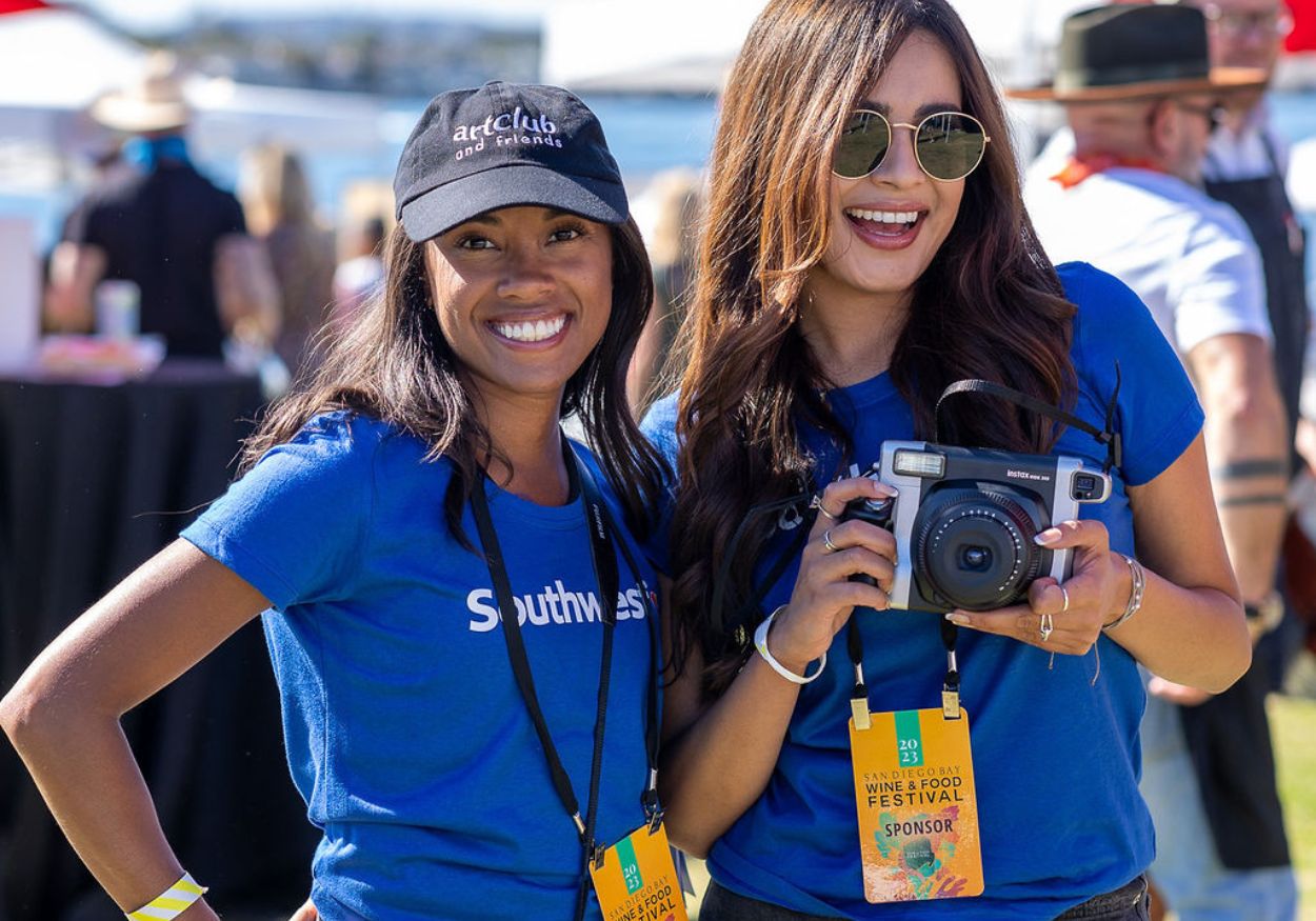 Two Southwest Airlines team members smile with an instant camera at the festival