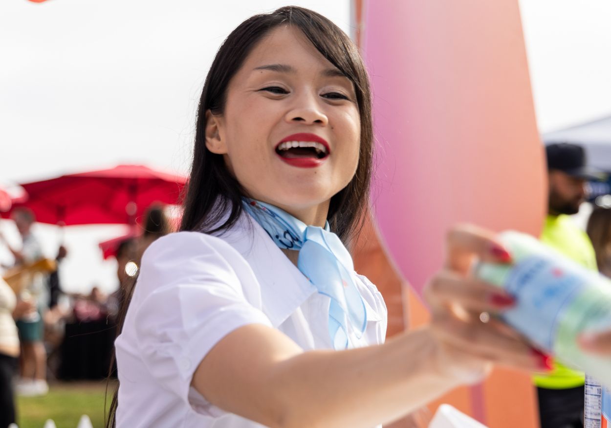 A smiling S.Pellegrino host hands out sparkling water to guests